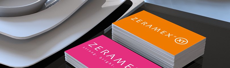 Zwei Stapel Visitenkarten mit Logos der Marke ZERAMEX® in pink und orange