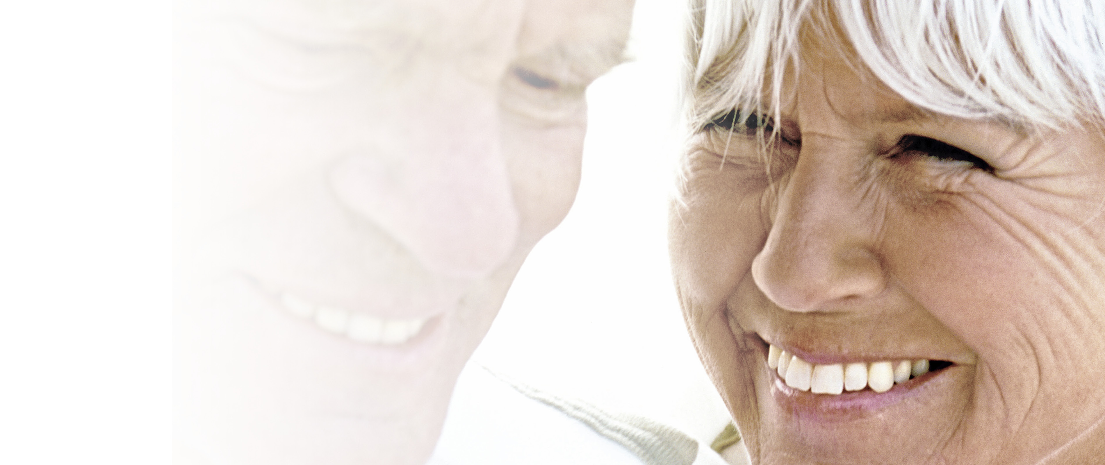 Ein älteres Paar mit weissen Haare, das sich anlächelt