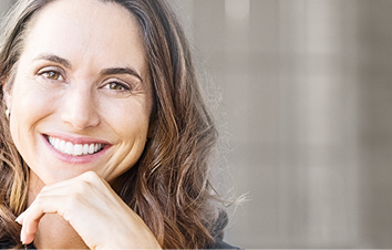 Patient with brown hair and white teeth laughs